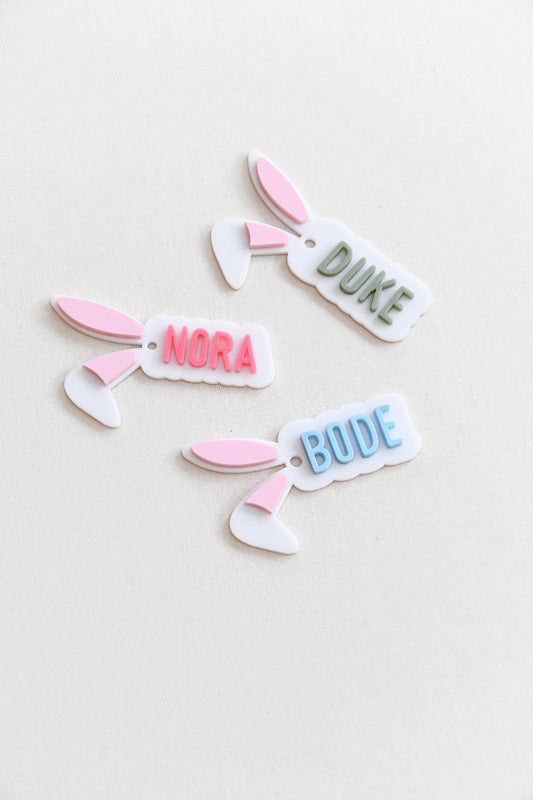 Bunny Ear Name Gift Tag. Custom name in your choice of pink, blue, or green, with soft light pink-filled ears for a sweet and festive look.