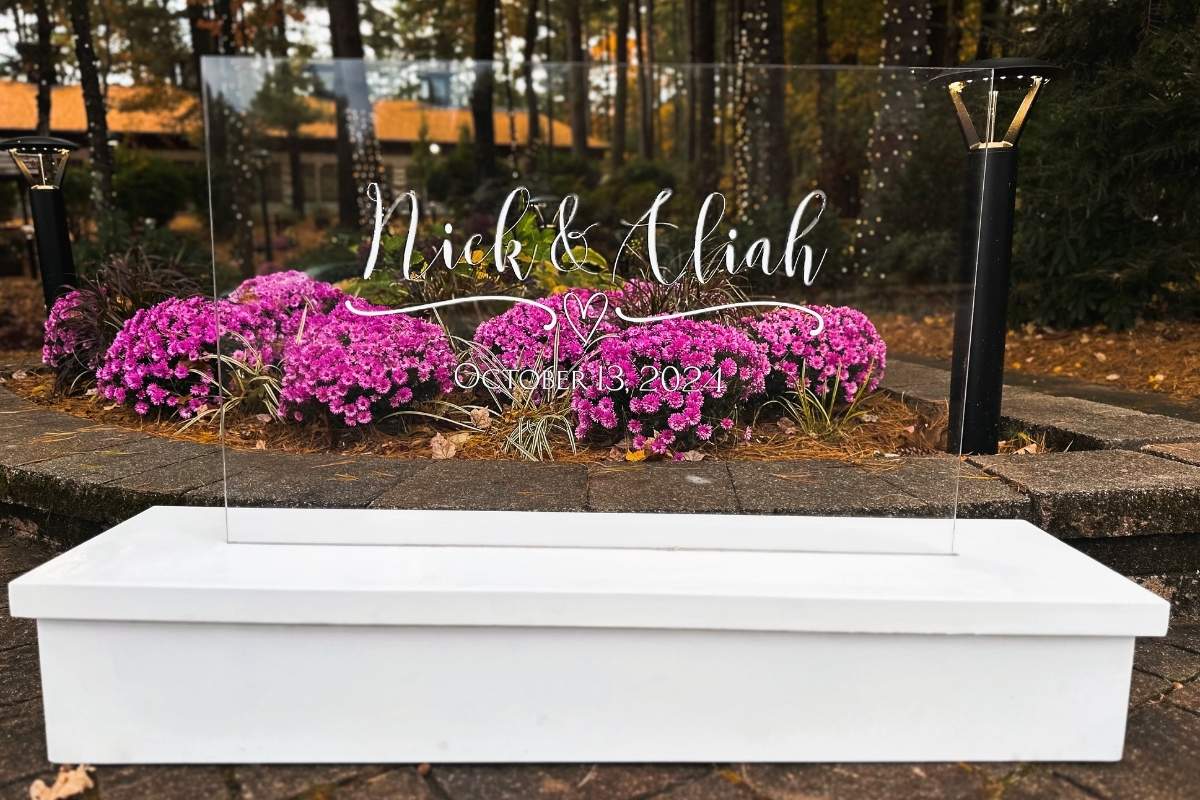 Custom personalized acrylic wedding sign with names and date of event. Standing in a light up white wood box.